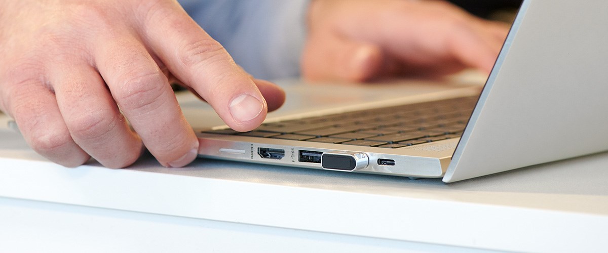 Plugging in a Fingerprint multi-factor authentication Security Key to a Laptop USB Port.