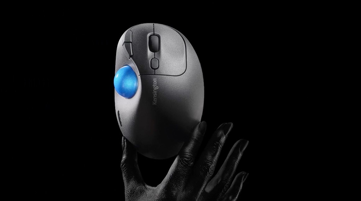 A Ergo Trackball held by a hand on a dark background.