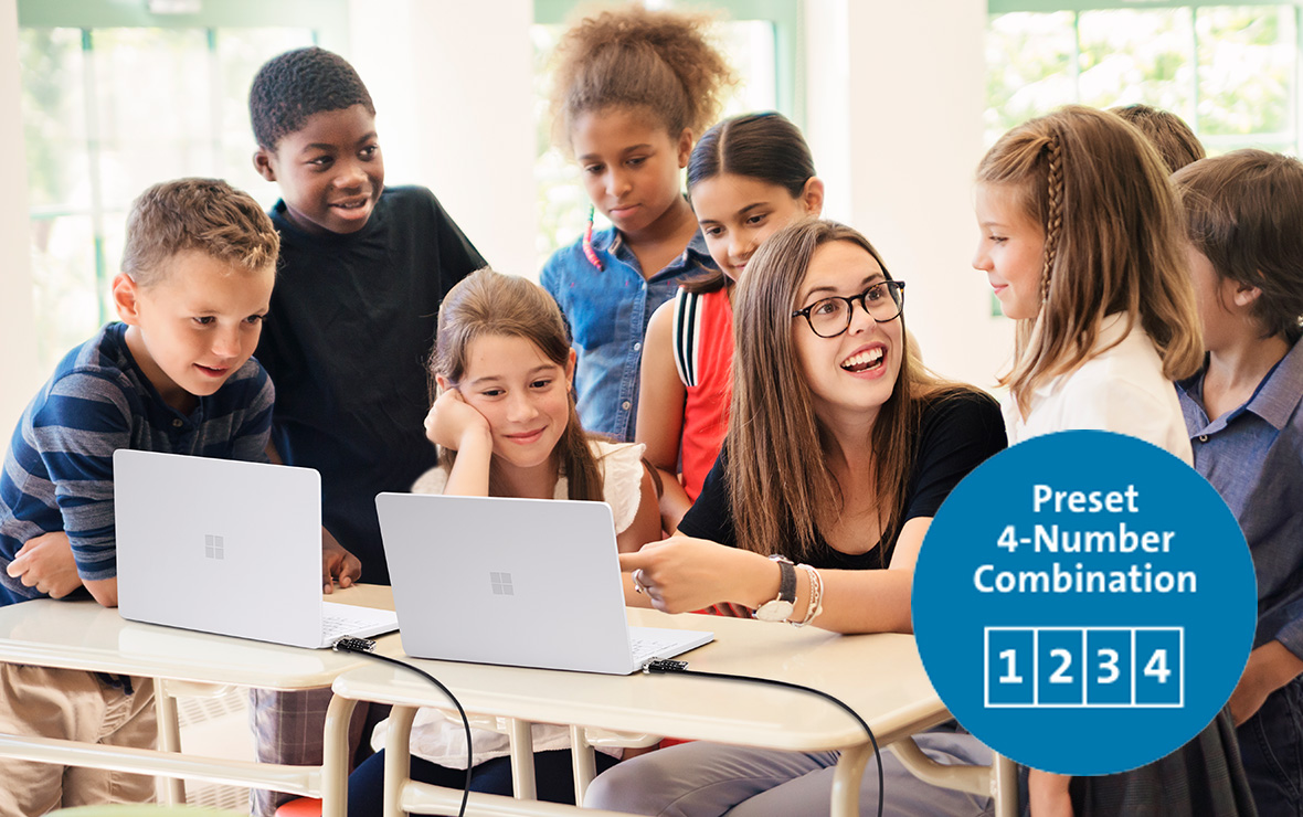 A young female teacher teaching some kids using laptops secured with a serialized lock