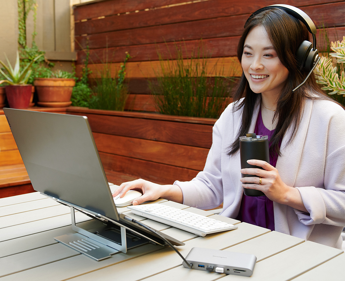 Woman working with a mobile setup and various Kensington products