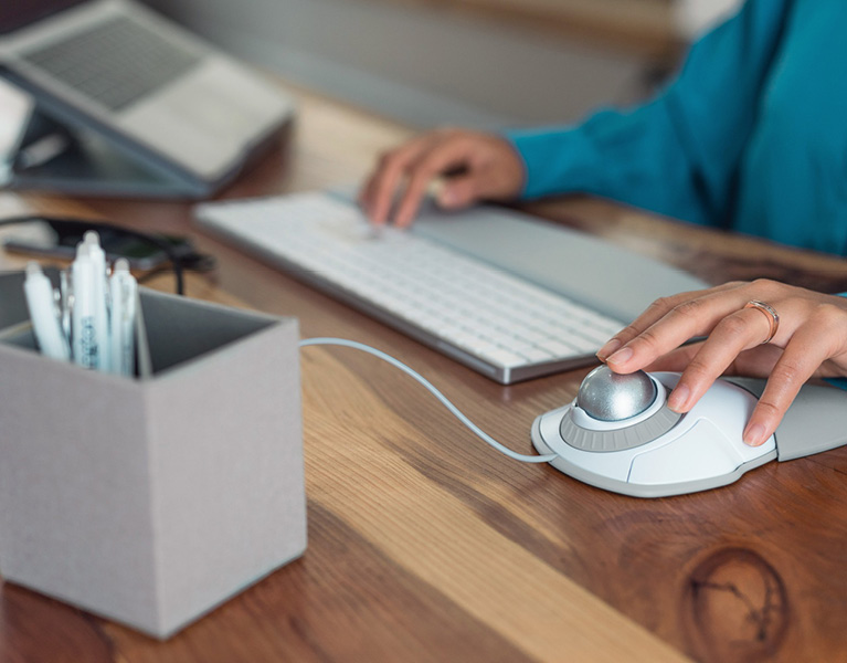 Woman using a Kensington Trackball at a desk