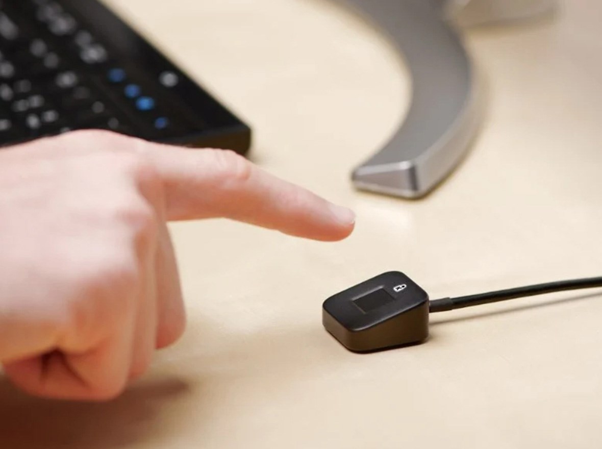 VeriMark™ Desktop device connected to a laptop and a male fingerprint on it in order to unlock it.