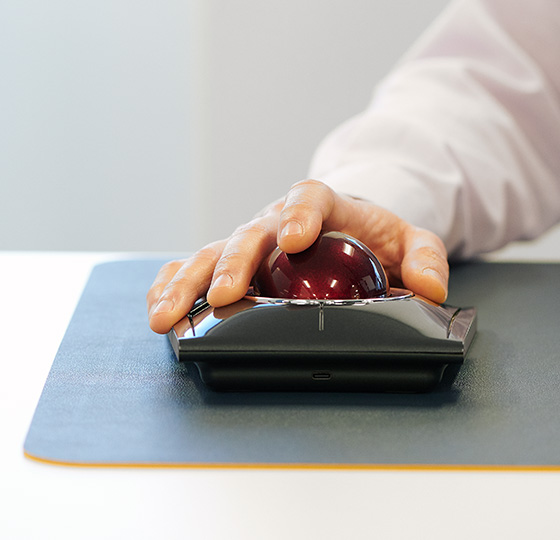 Close up of a professional using a Kensington SlimBlade™ Pro Trackball on a mousepad.