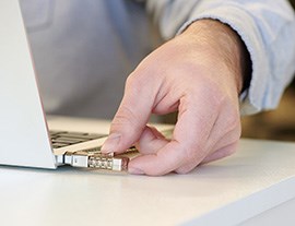 Male doctor working with his computer and surrounded by other doctors.