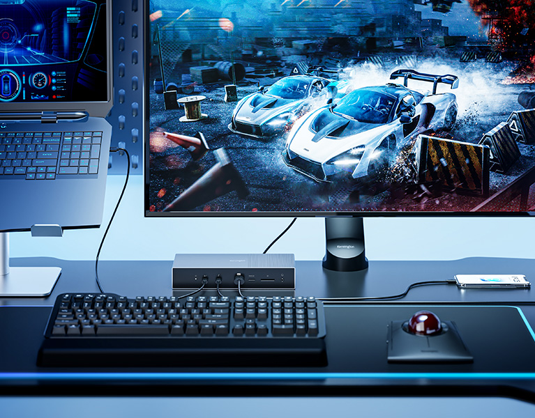 Professional gaming setup with blue accents featuring a Kensington SD5000T5 EQ Thunderbolt Docking Station, 4K monitor, Bluetooth Over-Ear Headset, and mechanical keyboard.