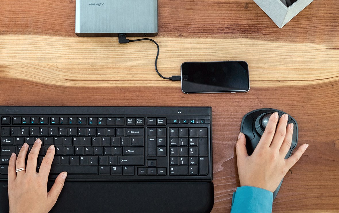 Close up to a female hands typing and scrolling with ergo devices.